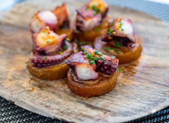 Spanish starter in fish restaurant in Getaria, grilled octopus with roasted potatoes and paprika, Basque Country, Spain