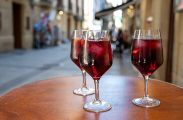 Glasses of cold sangria wine served outdoor in bar with view on old street in San Sebastian, Basque...