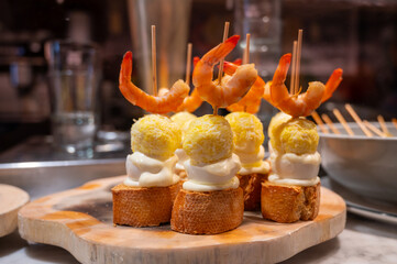 Typical snack in bars of Basque Country and Navarre, pinchos or pinxtos, small slices of bread upon which ingredient or mixture of ingredients is placed and fastened with skewers, San Sebastian, Spain