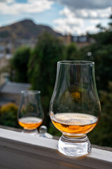 Glass of single malt scotch whisky served on old window sill in Scottisch house with view on old part of Edinburgh, Scotland, UK
