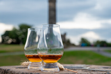 Tasting of single malt scotch whisky in glasses with view from Calton hill to new and old parts of Edinburgh city in rainy day, Scotland, UK