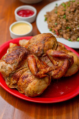 Grilled chicken with french fries on a wooden table.
