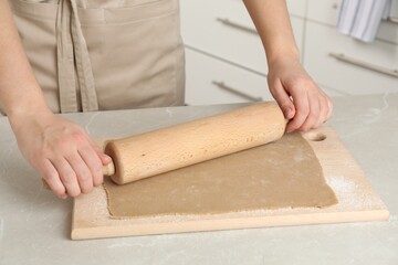 Woman making soba (buckwheat noodles) at light marble table indoors, closeup