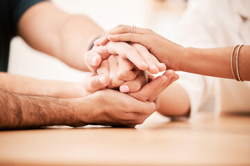 Support, care and family holding hands together at table to show empathy, love and hope. Closeup of...
