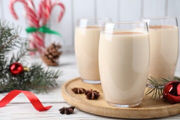 Delicious Christmas cocktail with liqueur on white wooden table, closeup. Space for text