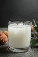 Fresh lychee juice on grey table, closeup