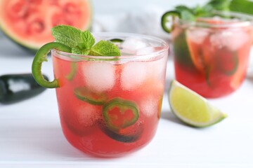 Spicy cocktail with jalapeno and mint on white table, closeup