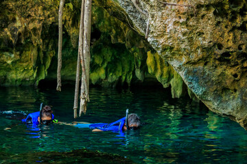 Some people is snorkeling on a cenote in Cancun Mexico