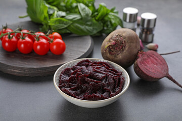 Bowl with tasty beet puree and ingredients on black table
