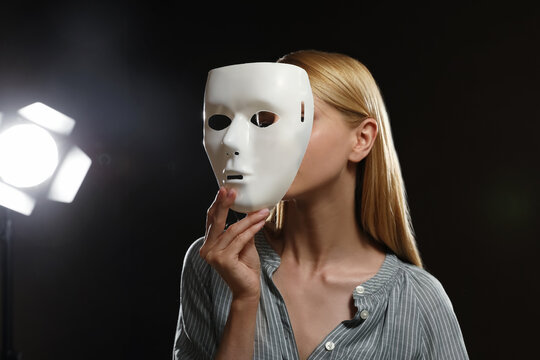 Professional actress with mask on stage in theatre