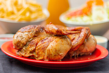 Grilled chicken with french fries on a wooden table.
