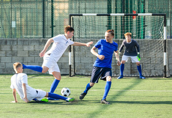 Obraz premium Football soccer players with ball. Footballers kicking football match on the pitch. Young teen soccer game