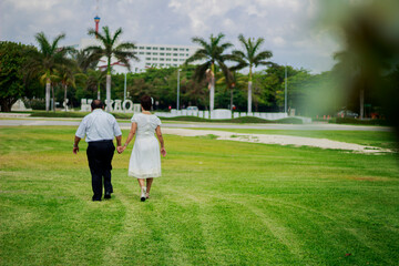 Couple of adults grandparents are walking on the park