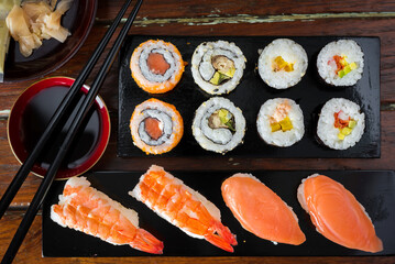 Sushi Set nigiri shrimp and salmon and sushi california rolls with avocado and maki, on wood,