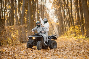 Man and woman driving quad bike in autumn forest © prostooleh