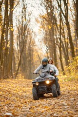 Man and woman driving quad bike in autumn forest © prostooleh