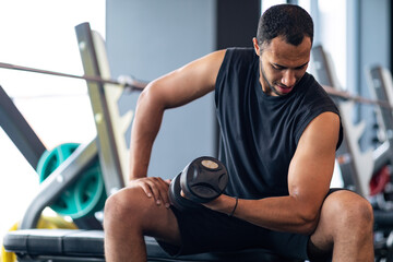 Muscular African American Guy Training With Dumbbell In Modern Gym