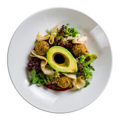vegetable salad with avocado,pear and falafel on white plate top view isolated on white background
