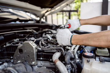 Auto mechanic repairman using a socket wrench working engine repair in the garage, change spare part, check the mileage of the car, checking and maintenance service concept.