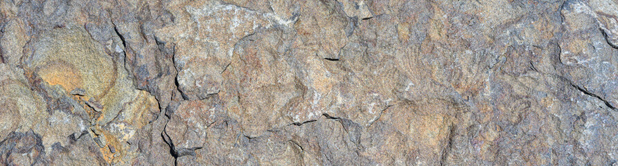 Closeup of multicolor dark rock, patterns and textures in nature as a background

