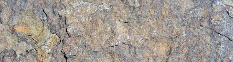 Closeup of multicolor dark rock, patterns and textures in nature as a background
