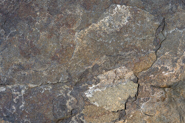 Closeup of multicolor dark rock, patterns and textures in nature as a background
