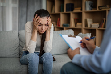 Obraz premium Despaired sad young caucasian lady suffering from mental problems listens to male doctor in office