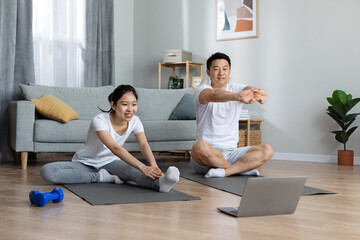 Cheerful japanese man and woman in sportswear exercising at home