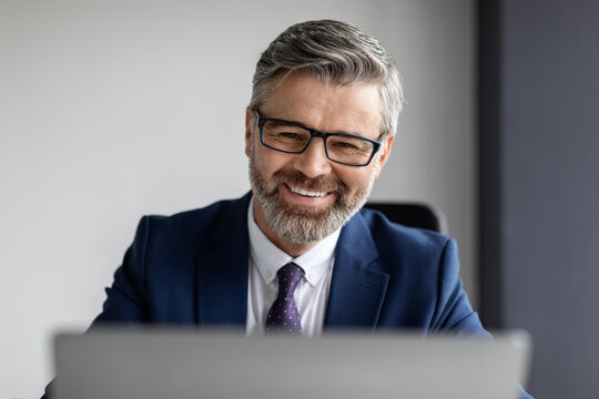 Handsome Bearded Middle Aged Businessman Wearing Eyeglasses Working With Laptop In Office