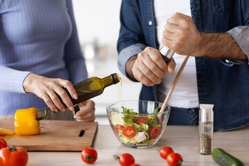 Unrecognizable elderly man and woman cooking together at home