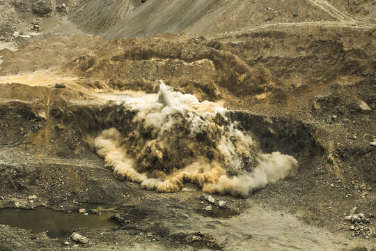 Blasting TNT explosion bomb rock in the open pit miner site