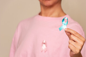 Woman holding blue ribbon for men's breast cancer day
