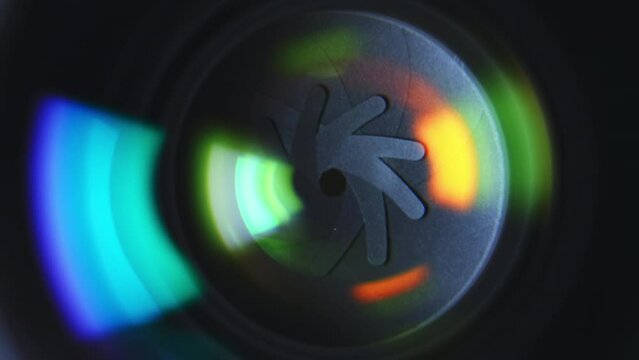 Close-up aperture blades inside of professional camera lens with green color reflections. High quality 4k footage