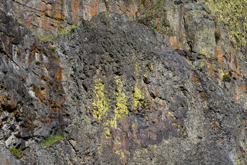 Closeup of multicolor dark rock, patterns and textures in nature as a background
