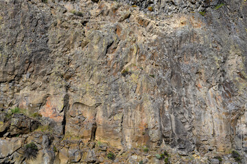 Closeup of multicolor dark rock, patterns and textures in nature as a background
