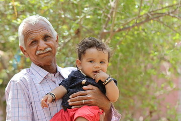 Photo together with little grand son in the dock in Indian Hindu grandfather garden
