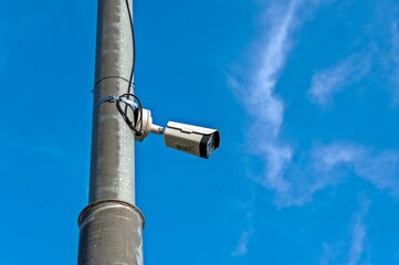 Fototapeta premium A video camera for surveillance is hanging on a pole