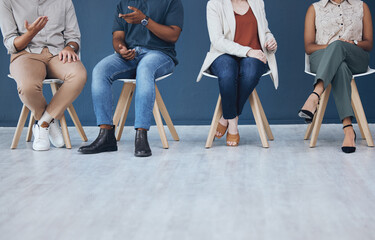 Fototapeta na wymiar Interview, human resources and recruitment with business people sitting in line on chairs in a studio or waiting area. Entrepreneur application and hiring for a vacancy at a small startup company