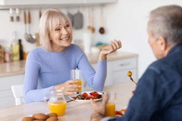 Smiling senior spouses enjoying healthy meal together
