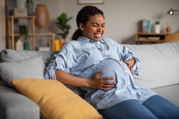 Pregnant Black Female Suffering From Pain Having Painful Spasm Indoors