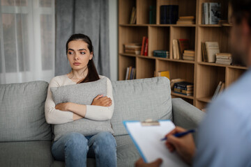 Obraz premium Unhappy sad young european woman listens to male doctor in office clinic interior
