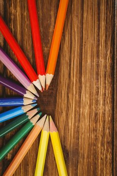 Color pencils arranged on wooden table
