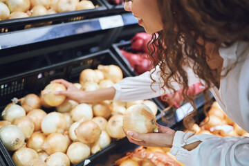 Supermarket, onion and customer shopping for healthy food, cooking and wellness product in grocery store. Happy, smile and black woman with nutrition vegetable choice on sale in retail shop for meal