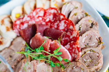 meat delicacies on a plate decorated with micro greens. 