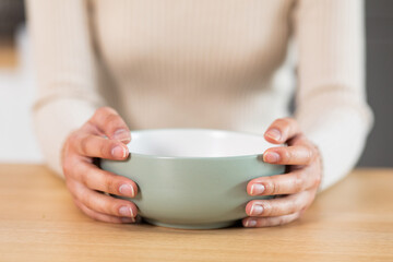Female hands holding empty plate, closeup photo