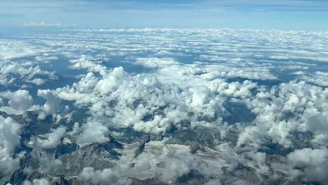 Aerial view taken from a jet cockpit of a alpine glacier in a summer day with almost no snow. Pilot point of view. Taken at 12000 metres high. 4k 60fps.