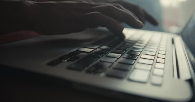 Close up of woman's hands typing on a laptop keyboard while working. Cinematic 4K.