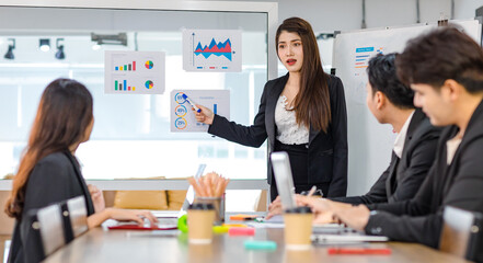 Asian young beautiful professional successful businesswoman presenter standing smiling in front of glass board after presenting while male female colleagues clapping hands thank you in meeting room