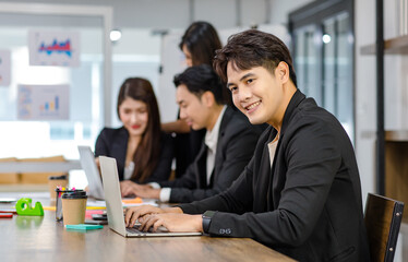 Group of millennial Asian young professional successful male businessmen and female businesswomen in formal suit sitting standing smiling screaming shouting holding fists up celebrating together