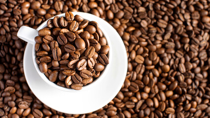 Roasted coffee beans in a white mug on a background of coffee beans.